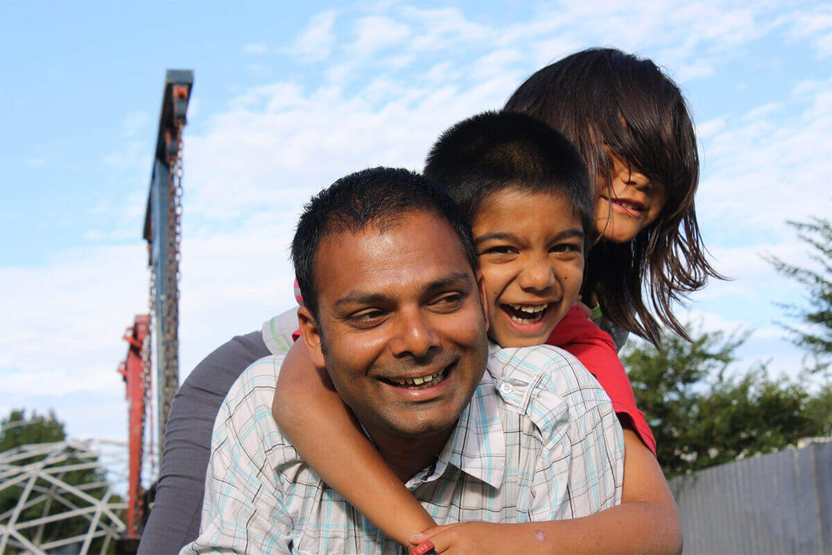 Debt free Father, Alpesh, plays with his two children in the park Debt free Father - Alpesh - plays with his two children in the park